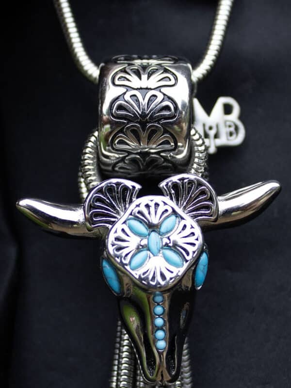 Close-up of a decorative metallic bull pendant with intricate patterns.
