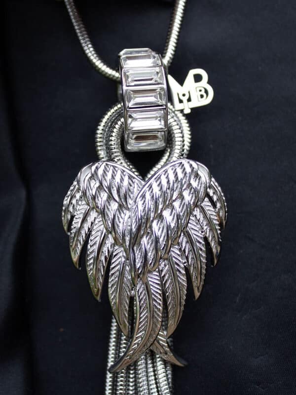 Close-up of a silver leaf-shaped pendant with intricate detailing.