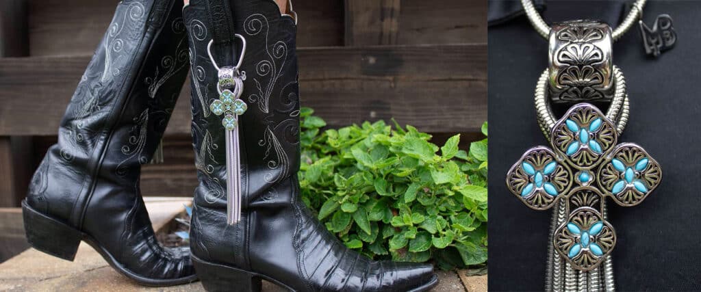 Black cowboy boots with intricate stitching and a decorative silver spur on green grass.
